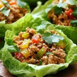 - 450 g gemahlenes Hühnerfleisch - 1 Esslöffel Sesamöl - 2 Knoblauchzehen, fein gehackt - 1 Esslöffel frischer Ingwer, fein gehackt - 1 rote Paprika, fein gewürfelt - 1 Karotte, gerieben - 3 Frühlingszwiebeln, in Ringe geschnitten - 3 Esslöffel Sojasauce - 2 Esslöffel Hoisinsauce - 1 Esslöffel Reisessig - 1 Esslöffel Sriracha (optional) - 1 Kopf Buttersalat (oder Eisbergsalat) - Sesamkörner zur Garnitur - Frischer Koriander zur Garnitur Die Zutaten sind frisch und einfach. Das Hühnerfleisch macht diesen Snack herzhaft. Sesamöl bringt einen nussigen Geschmack. Knoblauch und Ingwer sorgen für Aroma und Schärfe. Rote Paprika und Karotte bringen Farbe und Textur. Frühlingszwiebeln fügen einen frischen Crunch hinzu. Sojasauce und Hoisinsauce geben Tiefe. Reisessig sorgt für einen leichten Säurekick. Sriracha kann für mehr Schärfe hinzugefügt werden. Buttersalat dient als knackige Hülle für die Füllung. Sesamkörner und Koriander runden das Gericht geschmacklich ab. - Kalorien pro Portion: ca. 300 - Protein: 25 g - Fett: 15 g - Kohlenhydrate: 20 g Jede Portion hat gute Nährwerte. Das Gericht hat viel Protein und wenig Kohlenhydrate. Ideal für einen leichten Snack oder eine Mahlzeit. Es ist gesund und sättigend zugleich. Zuerst bereite alle Zutaten vor. Hier sind die Schritte: - 450 g gemahlenes Hühnerfleisch abwiegen. - 2 Knoblauchzehen und 1 Esslöffel frischen Ingwer fein hacken. - 1 rote Paprika in kleine Würfel schneiden. - 1 Karotte reiben. - 3 Frühlingszwiebeln in Ringe schneiden. - Wasche die Blätter des Buttersalats gründlich. - Lege die Salatblätter zum Trocknen auf ein Küchentuch. Jetzt wird das Gericht zubereitet: - Erhitze 1 Esslöffel Sesamöl in einer großen Pfanne bei mittlerer Hitze. - Füge die gehackten Knoblauchzehen und Ingwer hinzu. Brate sie für 1-2 Minuten. - Erhöhe die Hitze auf mittelhoch. Gib das gemahlene Hühnerfleisch in die Pfanne. - Brate das Hühnerfleisch 5-7 Minuten an. Zerbrich es mit einem Spatel in kleine Stücke. - Füge die gewürfelte Paprika und die geriebene Karotte hinzu. Brate alles für weitere 3-4 Minuten. - Rühre 3 Esslöffel Sojasauce, 2 Esslöffel Hoisinsauce, 1 Esslöffel Reisessig und Sriracha unter. Koche diese Mischung 2 Minuten, um die Aromen zu vereinen. - Nimm die Pfanne vom Herd und lasse die Mischung kurz abkühlen. Jetzt kommt der beste Teil: das Servieren. - Verwende einen Löffel, um die Hühnermischung in die Salatblätter zu füllen. - Garniere die Blätter mit Sesamkörnern und frischem Koriander. - Jetzt sind die asiatischen Chicken Lettuce Cups bereit zum Genießen! - Optimale Bratzeit für Hühnerfleisch: Brate das Hühnerfleisch für etwa 5 bis 7 Minuten. Achte darauf, dass es schön gebräunt und gut durchgegart ist. Diese Zeit hilft, die Feuchtigkeit im Fleisch zu halten und einen tollen Geschmack zu entwickeln. - Gemüse richtig dünsten: Dünste die Paprika und Karotte für 3 bis 4 Minuten. Dadurch bleiben die Farben lebendig und die Textur bleibt knackig. So schmeckt das Gemüse frisch und lecker. - Verwendung von verschiedenen Saucen: Probiere unterschiedliche Saucen aus, um den Geschmack zu variieren. Sojasauce bringt Salz, während Hoisinsauce Süße hinzufügt. Reisessig sorgt für eine leichte Säure. - Verwendung frischer Kräuter: Frischer Koriander macht die Lettuce Cups lebendig. Du kannst auch frische Minze oder Basilikum verwenden, um neue Aromen zu entdecken. Experimentiere mit Kräutern, die dir gefallen! {{image_4}} Du kannst das Hühnerfleisch ganz einfach ersetzen. Rindfleisch ist eine gute Wahl. Es hat einen reichhaltigen Geschmack und wird gut gewürzt. Du kannst auch Tofu verwenden. Tofu nimmt die Aromen gut auf und macht das Gericht vegetarisch. Die Zubereitung bleibt gleich. Achte darauf, den Tofu gut zu braten, damit er knusprig wird. Das Gemüse in den Lettuce Cups ist sehr flexibel. Du kannst weitere Gemüsesorten hinzufügen. Zucchini, Pilze oder Erbsen passen gut dazu. Auch saisonale Gemüse wie Spargel oder Kürbis sind toll. Sie bringen frische Farben und Texturen in das Gericht. Experimentiere mit deinem Lieblingsgemüse. Wenn du es weniger scharf magst, verwende weniger Sriracha. Du kannst auch andere Scharfmacher ausprobieren. Frische Chili oder Paprikapulver sind gute Alternativen. So kannst du den Geschmack nach deinem Wunsch anpassen. Schärfe macht das Essen spannend, also finde die perfekte Balance für dich. - Wie lange halten sich die Reste? Reste der asiatischen Chicken Lettuce Cups sind im Kühlschrank etwa 3 Tage haltbar. Bewahre sie in einem luftdichten Behälter auf. So bleiben die Aromen frisch und das Hühnerfleisch saftig. - Lagerbehälter richtig wählen Wähle einen Behälter, der gut schließt. Ein Glasbehälter ist ideal, da er keine Gerüche aufnimmt. Plastiktüten sind auch praktisch, aber achte darauf, die Luft herauszudrücken. - Tipps zum Einfrieren der Mischung Du kannst die Hühnerfüllung gut einfrieren. Lass sie zuerst abkühlen. Fülle sie dann in einen gefrierfesten Behälter oder in Gefrierbeutel. Markiere das Datum, um den Überblick zu behalten. - Auftauen und Aufwärmen Um die Mischung aufzutauen, lege sie über Nacht in den Kühlschrank. Erhitze sie dann in einer Pfanne bei mittlerer Hitze. Füge ein wenig Wasser hinzu, um das Hühnerfleisch wieder saftig zu machen. So bleibt der Geschmack erhalten. Um das Rezept vegan zu machen, kannst du das Hühnerfleisch durch pflanzliche Proteinoptionen ersetzen. Tofu oder Tempeh sind gute Alternativen. Du kannst auch gewürztes Seitan verwenden. Für die Sojasauce, die oft Fischsoße enthält, nutze Tamari oder eine miso-basierte Sauce. Diese Optionen geben deinem Gericht einen tollen Geschmack und eine schöne Textur. Ja, du kannst die Salatblätter leicht ersetzen. Versuche es mit anderen Blattsalaten wie Römersalat oder Mangold. Du kannst auch Reis- oder Maiswraps verwenden. Diese Optionen sind ebenfalls lecker und bieten eine andere Textur. Achte darauf, dass die Blätter groß genug sind, um die Füllung zu halten. Um das Gemüse zu würzen, kannst du verschiedene Gewürze und Kräuter verwenden. Frischer Koriander passt gut zu diesem Gericht. Auch etwas Limettensaft bringt Frische. Du kannst zusätzlich Chili-Flocken für mehr Schärfe hinzufügen. Probiere auch Knoblauchpulver oder gerösteten Sesam, um den Geschmack zu vertiefen. Zusammenfassend haben wir ein leckeres Rezept mit einfachen Zutaten und klaren Schritten betrachtet. Die Hauptzutaten, wie gemahlenes Hühnchen und frisches Gemüse, sorgen für tollen Geschmack und Nährstoffgehalt. Außerdem haben wir Variationen besprochen, damit du das Rezept nach deinem Geschmack anpassen kannst. Denk an die Tipps für die perfekte Konsistenz und Lagerung. Jetzt liegt es an dir, dieses Rezept auszuprobieren und zu genießen!