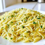 - 1 Tasse Orzo-Pasta - 2 Esslöffel ungesalzene Butter - 3 Knoblauchzehen, gehackt - 1 Esslöffel frischer Zitronensaft - 1 Teelöffel Zitronenschale - 1 Esslöffel frische Petersilie, gehackt - 1 Esslöffel frisches Basilikum, gehackt - Salz und Pfeffer nach Geschmack - ¼ Tasse geriebener Parmesan (optional) Die Hauptzutaten sind einfach und frisch. Orzo ist eine kleine Pasta, die leicht zu kochen ist. Die ungesalzene Butter gibt ein tolles Aroma. Knoblauch bringt viel Geschmack. Zitronensaft und -schale geben Frische. Petersilie und Basilikum sorgen für grüne Farbe und Geschmack. Parmesan ist ein leckerer Zusatz, aber nicht nötig. Sie können noch mehr Geschmack hinzufügen. Ein Spritzer Chiliöl kann das Gericht schärfer machen. Gehackte Oliven geben eine salzige Note. Für eine nussige Note passen geröstete Pinienkerne gut. Wenn Sie es cremiger möchten, fügen Sie mehr Parmesan hinzu. Diese zusätzlichen Zutaten machen das Rezept noch spannender. Wählen Sie frische Kräuter aus. Sie haben mehr Geschmack als getrocknete. Achten Sie darauf, dass die Orzo-Pasta keine Zusatzstoffe hat. Die Butter sollte frisch und ungesalzen sein. Kaufen Sie Bio-Zitronen für den besten Geschmack. Wenn Sie Parmesan verwenden, nehmen Sie einen hochwertigen Käse. Diese kleinen Schritte machen einen großen Unterschied! Zuerst bringe ich 4 Tassen gesalzenes Wasser in einem mittelgroßen Topf zum Kochen. Das Wasser muss sprudelnd sein. Dann füge ich 1 Tasse Orzo-Pasta hinzu. Ich koche die Orzo für etwa 8 bis 10 Minuten. Es ist wichtig, dass die Pasta al dente bleibt. Das bedeutet, sie sollte noch etwas Biss haben. Wenn die Orzo fertig ist, lasse ich sie gut abtropfen. Während die Orzo kocht, schmelze ich 2 Esslöffel ungesalzene Butter in einer großen Pfanne bei mittlerer Hitze. Sobald die Butter geschmolzen ist, füge ich 3 gehackte Knoblauchzehen hinzu. Ich brate den Knoblauch etwa 1 Minute lang an. Dabei rühre ich häufig, damit der Knoblauch nicht bräunt. Der Duft ist einfach himmlisch. Wenn die Orzo abgetropft ist, gebe ich sie direkt in die Pfanne mit der Knoblauchbutter. Dann füge ich 1 Esslöffel frischen Zitronensaft und 1 Teelöffel Zitronenschale hinzu. Auch 1 Esslöffel gehackte Petersilie und 1 Esslöffel gehacktes Basilikum kommen jetzt dazu. Ich vermenge alles gut. Damit die Orzo gleichmäßig mit der Kräuterbutter bedeckt ist, ist gründliches Mischen wichtig. Zum Schluss schmecke ich das Gericht mit Salz und Pfeffer ab. Man kann auch ¼ Tasse geriebenen Parmesan hinzufügen, wenn man möchte. Ich lasse die Mischung etwa eine Minute ruhen. So können sich die Aromen gut entfalten. Um die perfekte Orzo-Pasta zu kochen, beginne mit viel Wasser. Ich nutze immer 4 Tassen gesalzenes Wasser. Das sorgt dafür, dass die Pasta gleichmäßig gart und nicht klebt. Koche die Orzo gemäß den Anweisungen auf der Verpackung, etwa 8 bis 10 Minuten. Überprüfe die Konsistenz, bis sie al dente ist. Wenn du sie zu lange kochst, wird sie matschig. Frische Kräuter bringen mehr Geschmack und Aroma als getrocknete Kräuter. Ich benutze oft frische Petersilie und Basilikum. Sie verleihen der Orzo-Pasta eine lebendige Note. Wenn frische Kräuter nicht verfügbar sind, nutze die getrocknete Variante. Sie sind praktisch, haben aber weniger Intensität. In diesem Fall verwende weniger, etwa einen Teelöffel getrocknete Kräuter. Du kannst das Rezept an deinen Geschmack anpassen. Füge zum Beispiel mehr Zitronensaft hinzu, wenn du es frisch magst. Für einen würzigeren Geschmack sind rote Paprika oder Chili-Flocken eine gute Wahl. Wenn du Käse liebst, mische mehr Parmesan unter die Pasta. Experimentiere mit verschiedenen Kräutern. Dill oder Thymian passen auch gut. Sei kreativ und finde deinen eigenen Lieblingsgeschmack! {{image_4}} Für eine vegane Version von Minute Kräuterbutter-Orzo, ersetze die Butter durch pflanzliche Margarine. Diese gibt einen ähnlichen Geschmack. Du kannst auch Olivenöl verwenden. Das bringt eine tolle Frische. Achte darauf, dass der Parmesan vegan ist oder lasse ihn ganz weg. Der Geschmack bleibt trotzdem großartig. Um dein Gericht noch bunter und nahrhafter zu machen, füge Gemüse hinzu. Spinat, Erbsen oder Paprika passen sehr gut. Einfach das Gemüse in die Pfanne geben, während der Knoblauch brät. Für mehr Protein kannst du Kichererbsen oder gebratenes Hähnchen hinzufügen. Diese Zutaten machen das Gericht sättigender und vollwertiger. Minute Kräuterbutter-Orzo passt super zu vielen Beilagen. Ein frischer Salat mit Tomaten und Gurken ergänzt das Gericht perfekt. Auch gegrillte Zucchini oder Auberginen sind eine tolle Wahl. Sie bringen Farbe und Geschmack. Du kannst auch etwas Brot dazu reichen, um die köstliche Kräuterbutter aufzusaugen. Um Reste von Minute Kräuterbutter-Orzo aufzubewahren, lassen Sie die Pasta zuerst abkühlen. Füllen Sie die abgekühlte Orzo in einen luftdichten Behälter. Sie können auch Frischhaltefolie verwenden. Achten Sie darauf, dass die Reste gut verschlossen sind. So bleiben sie frisch und schmackhaft. Wenn Sie die Orzo wieder aufwärmen möchten, fügen Sie einen kleinen Spritzer Wasser oder Brühe hinzu. Das hilft, die Pasta feucht zu halten. Erwärmen Sie die Orzo in einer Pfanne bei niedriger Hitze. Rühren Sie oft um, damit sie gleichmäßig warm wird. Sie können auch die Mikrowelle benutzen, aber denken Sie daran, die Orzo abzudecken. Im Kühlschrank hält sich die Minute Kräuterbutter-Orzo etwa 3 bis 4 Tage. Wenn Sie die Orzo länger aufbewahren möchten, können Sie sie einfrieren. In einem gefrierfesten Behälter hält sie sich bis zu 3 Monate. Stellen Sie sicher, dass Sie die Orzo gut beschriften, damit Sie das Datum wissen. Das Kochen von Orzo dauert etwa 8 bis 10 Minuten. Zuerst bringst du 4 Tassen gesalzenes Wasser zum Kochen. Dann gibst du die Orzo-Pasta hinein. Rühre gelegentlich um, damit sie nicht kleben bleibt. Wenn die Pasta al dente ist, sei sie ab. Das ist der perfekte Zeitpunkt für die nächste leckere Zubereitung. Ja, du kannst andere Kräuter verwenden! Petersilie und Basilikum sind frisch und lecker, aber du kannst auch Schnittlauch oder Koriander probieren. Frische Kräuter bringen tollen Geschmack. Trockene Kräuter sind auch okay, aber frische sind am besten. Experimentiere mit deinen Lieblingskräutern, um neue Aromen zu entdecken. Leider ist Orzo nicht glutenfrei. Orzo wird aus Hartweizengrieß gemacht. Das bedeutet, dass es Gluten enthält. Wenn du eine glutenfreie Option möchtest, kannst du glutenfreie Pasta verwenden. Viele Marken bieten glutenfreie Alternativen an. So kannst du trotzdem eine köstliche Kräuterbutter-Pasta genießen. Die Minute Kräuterbutter-Orzo ist einfach zuzubereiten und voller Geschmack. Wir haben die besten Zutaten und Tipps für die perfekte Zubereitung geteilt. Denk an frische Kräuter und verschiedene Variationen, um deinem Gericht einen eigenen Twist zu geben. Die richtige Lagerung sorgt dafür, dass Reste frisch bleiben. Jetzt kannst du dein Orzo kreativ anpassen und genießen. Experimentiere ruhig mit anderen Kräutern und Gemüse, um das Gericht zu verfeinern!